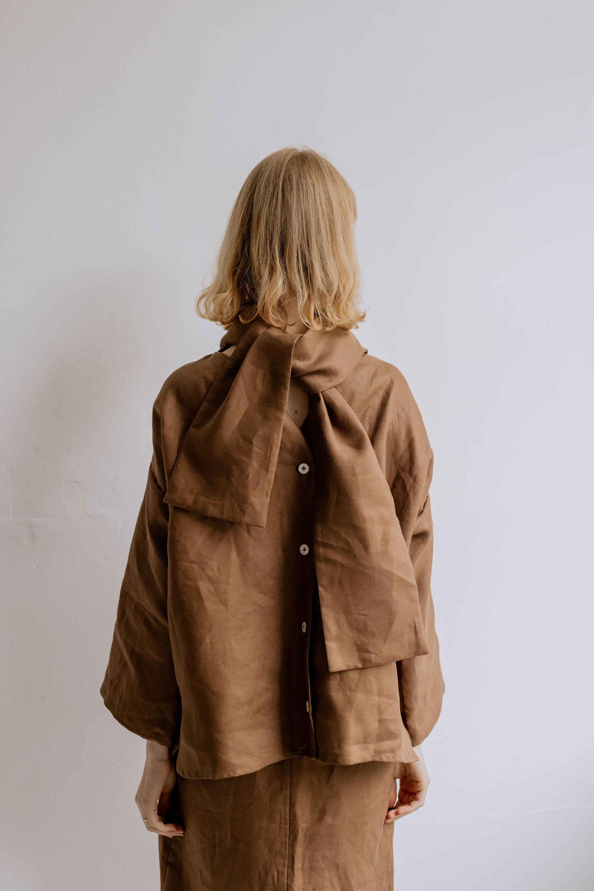 FREYA | CHOCOLATE | Our much loved Freya Blouse in an updated chocolate colour way. The shirt has an oversized collar that is secured with a tie at the back. You can play around with how the collar folds to suit your own look. In keeping with the versatil