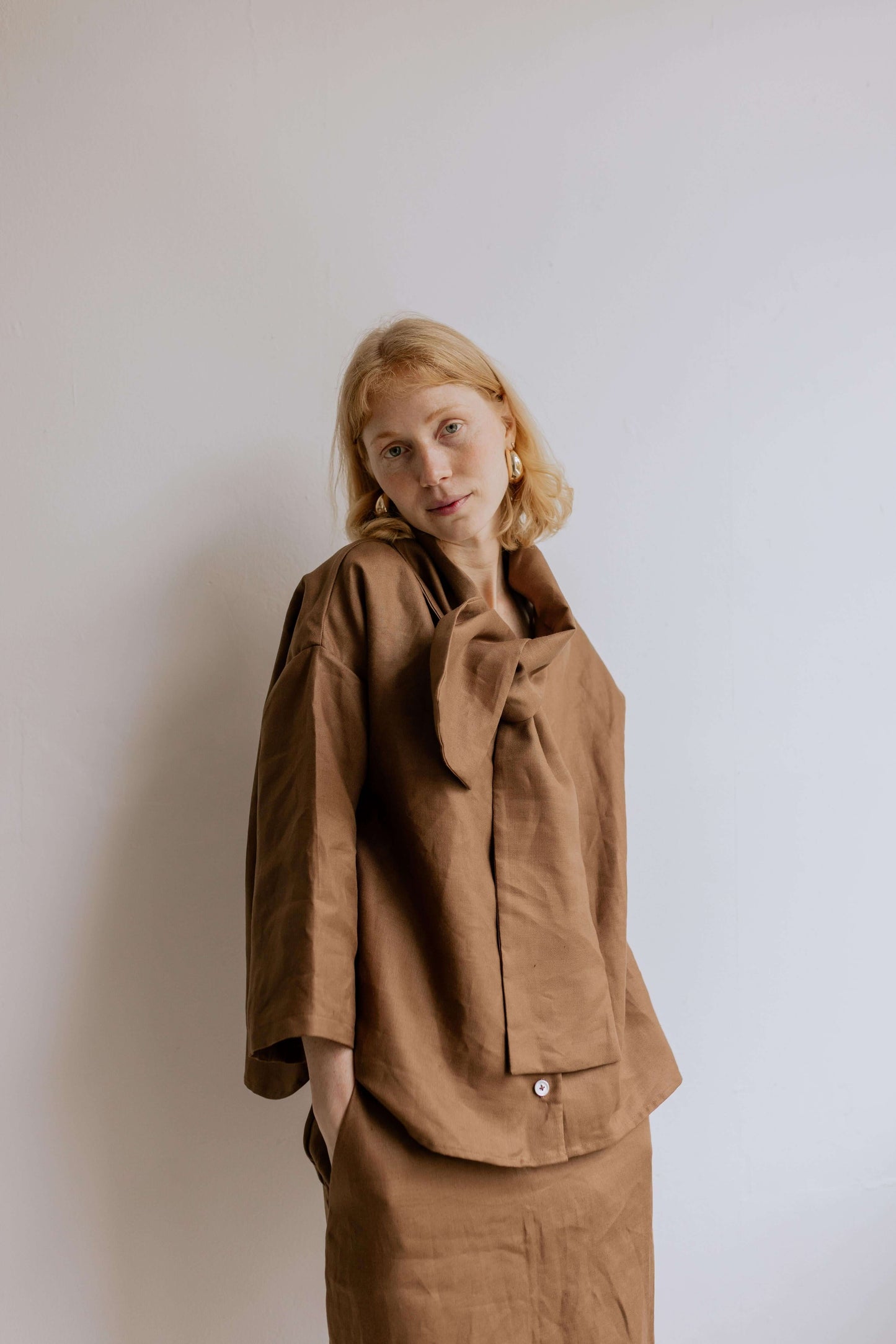 FREYA | CHOCOLATE | Our much loved Freya Blouse in an updated chocolate colour way. The shirt has an oversized collar that is secured with a tie at the back. You can play around with how the collar folds to suit your own look. In keeping with the versatil