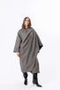 Grey cocoon-style cape dress worn with black boots, shown full length against a clean studio backdrop.
