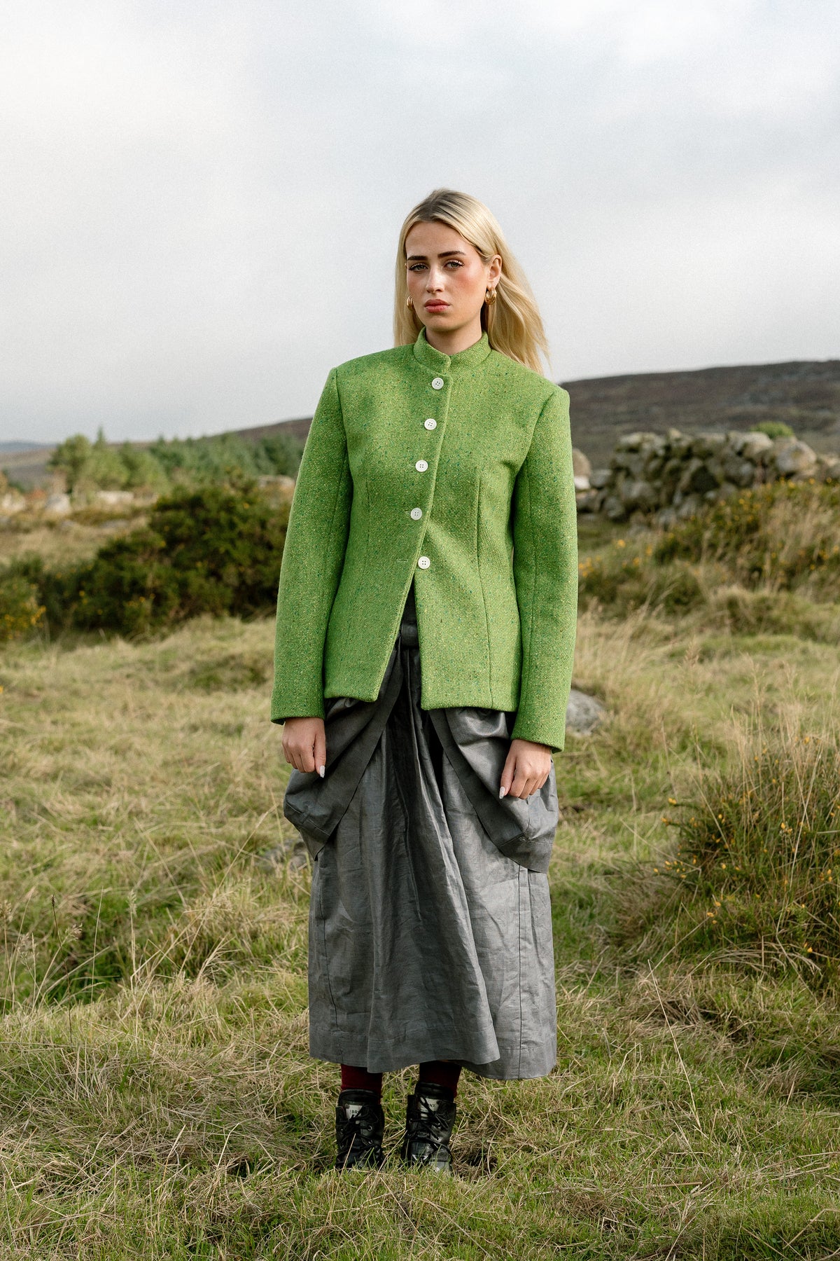 Beetled Bow Skirt in Slate with the Inheritance Blazer in Shamrock, full-length campaign photograph by Emma Kenny.