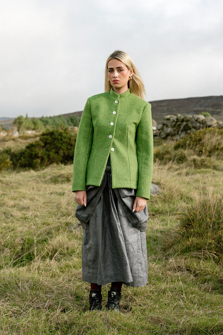 Beetled Bow Skirt in Slate with the Inheritance Blazer in Shamrock, full-length campaign photograph by Emma Kenny.