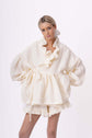 Cream ruffled blouse and shorts set shown full length, highlighting gathered details and soft volume.