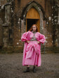 Model in a Loinnir Pink coat outside a stone chapel, Kept for Good AW26
