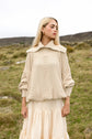 The Aran Jumper, a cream cable knit with a wide crochet-edged collar