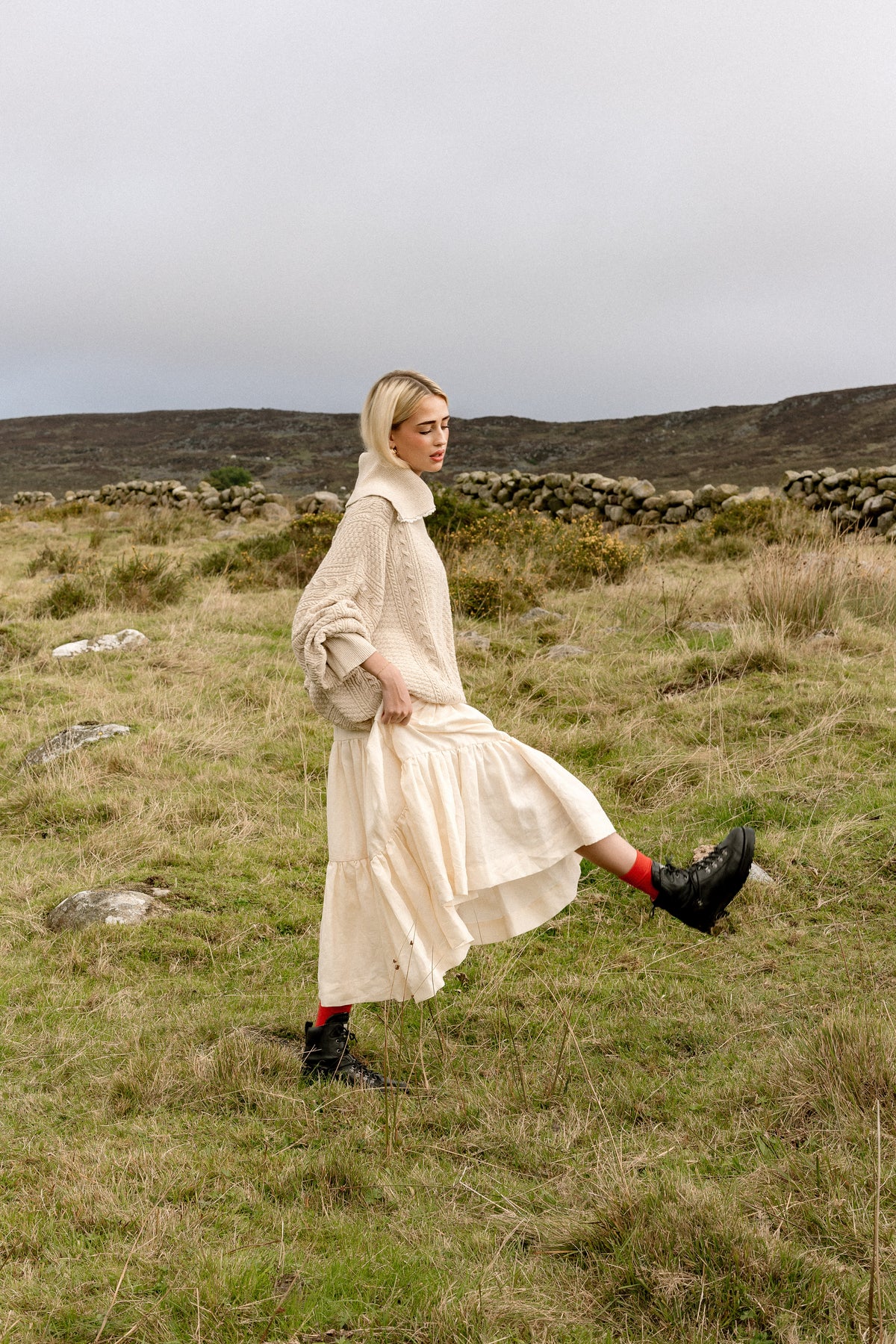 The Aran Jumper in movement, walking through long grass