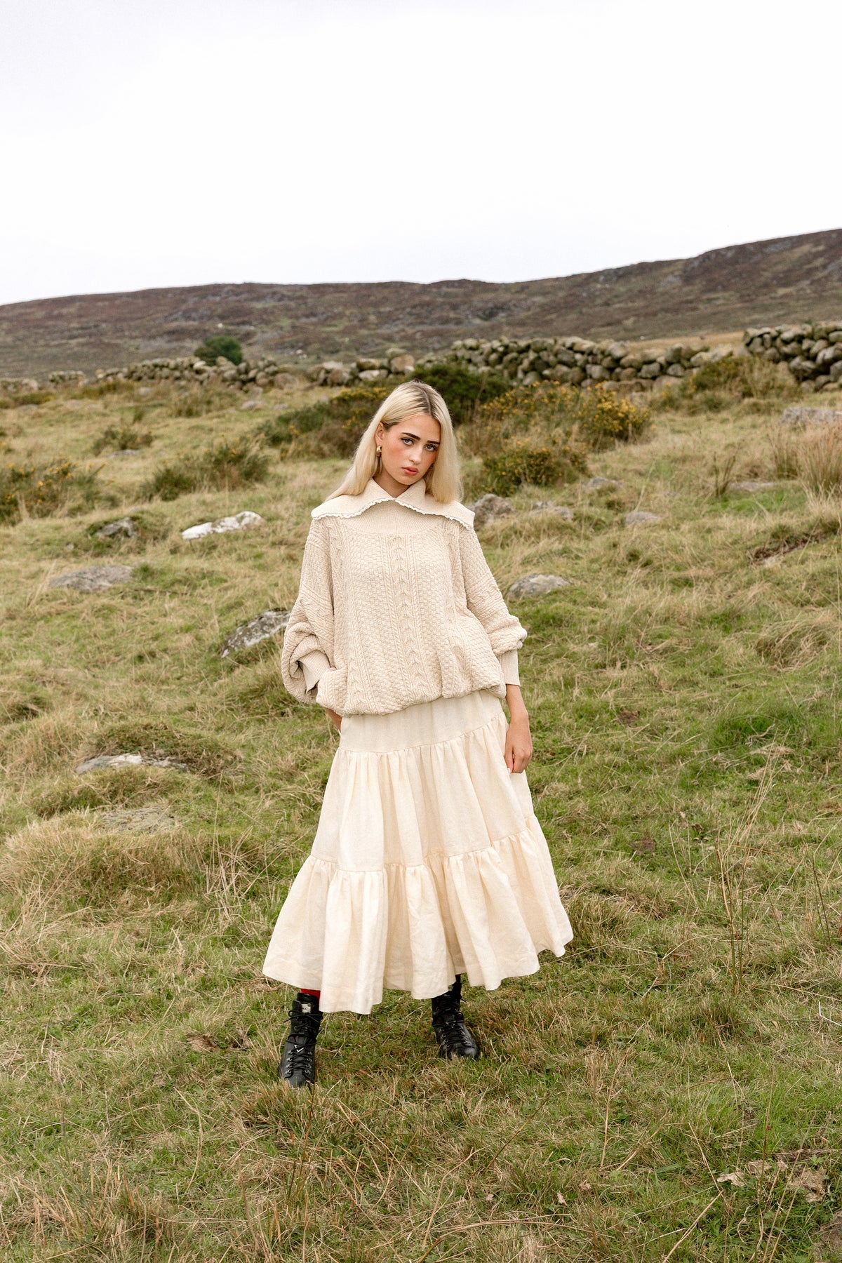 The Aran Jumper worn full length over a cream linen skirt