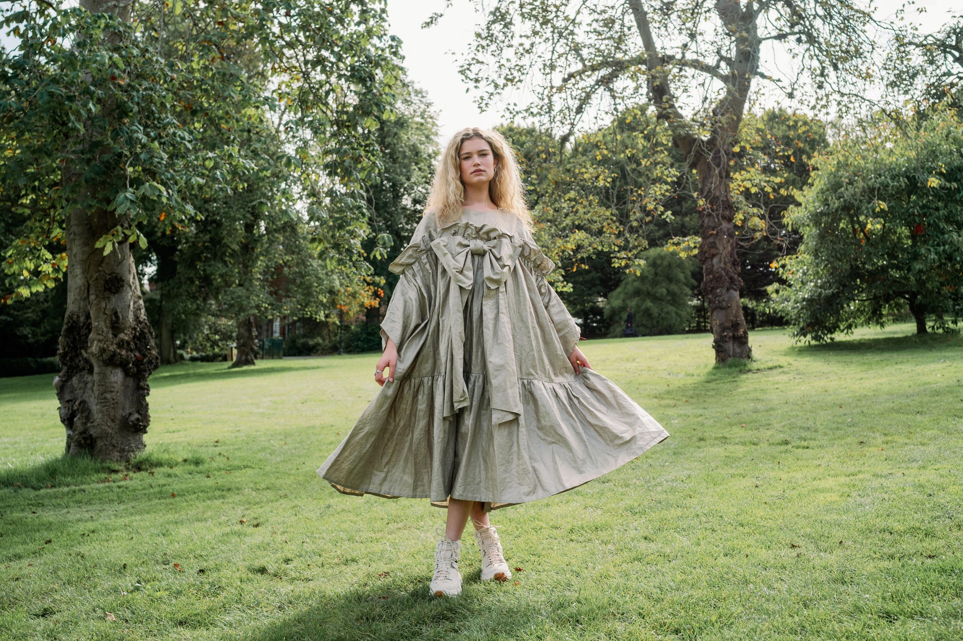 BOW DRESS | A new shape for AW23, The Bow Dress is one of our most playful. The dress is an oversized shape with gathered tiered details. The frill and bow detail at the front is the show-stopper. We have created this one in a beige/gold beetled linen whi