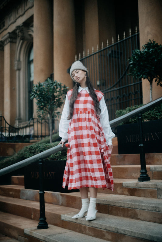 PINAFORE | PINK/RED CHECK | ONLY AVAILABLE FOR CHRISTMAS DELIVERY IF ORDERED FROM THE U.K.Our new pinafore is a really fun layering piece for the festive season. Featuring three bows on each side, she can be worn as a dress or layered over our Cadhla shir