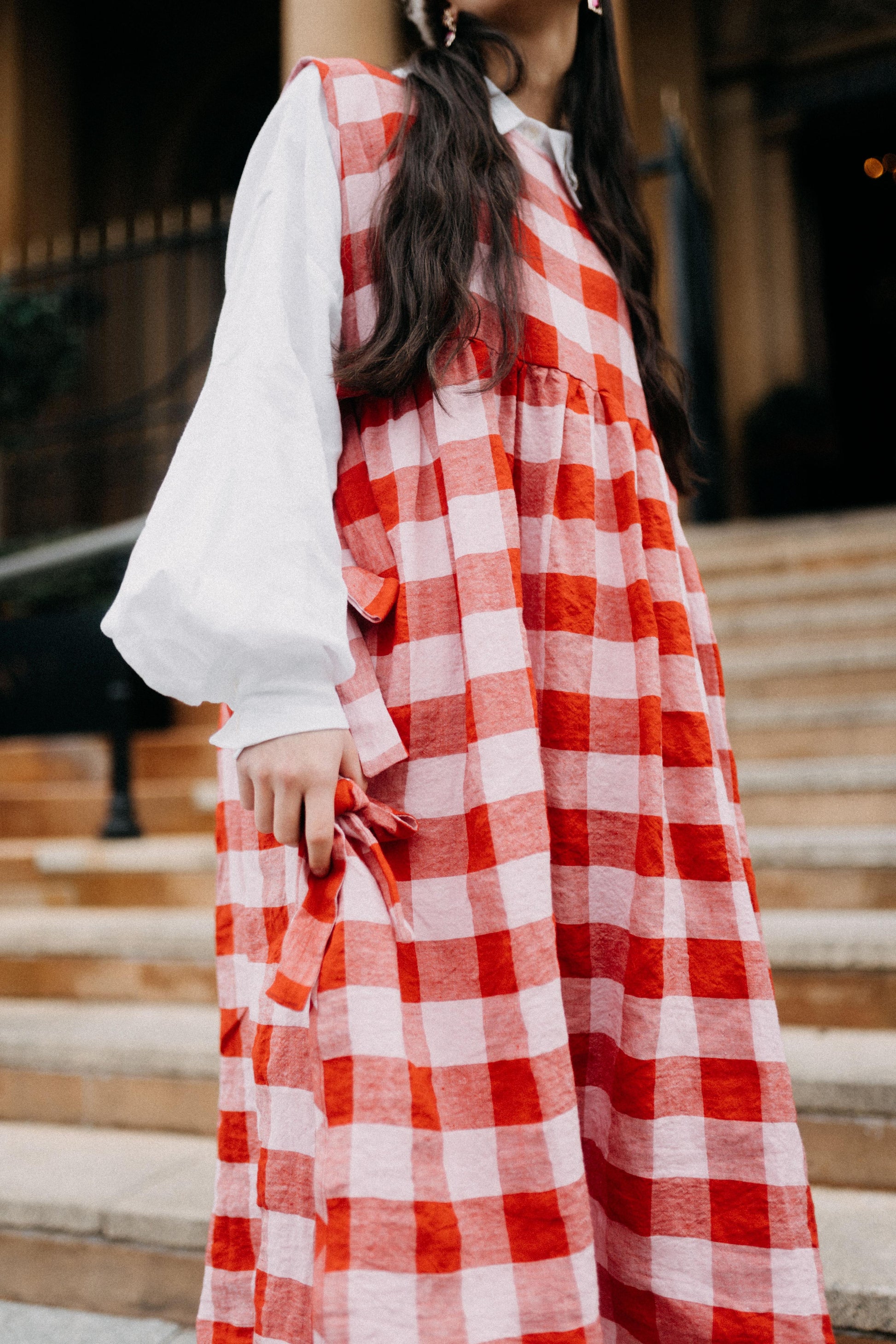 PINAFORE | PINK/RED CHECK | ONLY AVAILABLE FOR CHRISTMAS DELIVERY IF ORDERED FROM THE U.K.Our new pinafore is a really fun layering piece for the festive season. Featuring three bows on each side, she can be worn as a dress or layered over our Cadhla shir